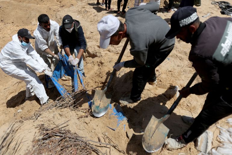 People work to move into a cemetery bodies of Palestinians killed during Israel's military offensive and buried at Nasser hospital, amid the ongoing conflict between Israel and the Palestinian Islamist group Hamas, in Khan Younis in the southern Gaza Strip, April 21, 2024. REUTERS/Ramadan Abed